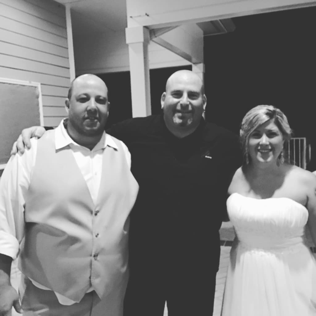Black and white portrait of Gary Lucca with a bride and groom from an early career Lowcountry reception